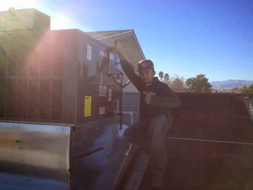 HVAC technician performing AC Tune-Up on a rooftop unit in Cleveland Heights